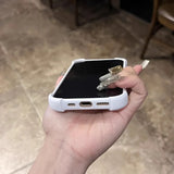 Hand holding a white smartphone with long, ornate fingernails.