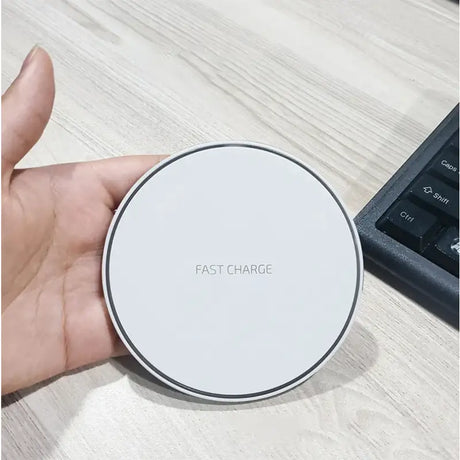 A hand holding a wireless charger