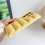 A hand holding a yellow leather case