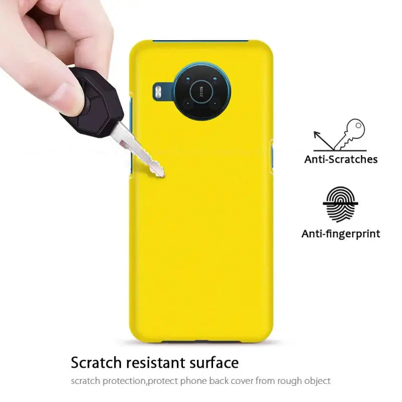 a hand holding a yellow phone case with a camera attached to it