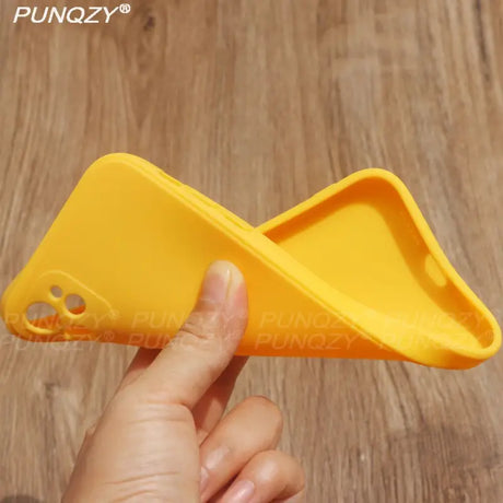 A hand holding a yellow plastic object