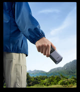 Handheld electronic device being gripped by a person’s hand.