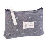 the small pouch bag is made from a denim fabric with a small white flower pattern