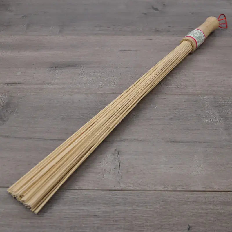 a wooden stick with a red handle on a wooden floor