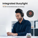 Headset with an integrated ’busylight’ feature worn by a smiling person working at a computer.