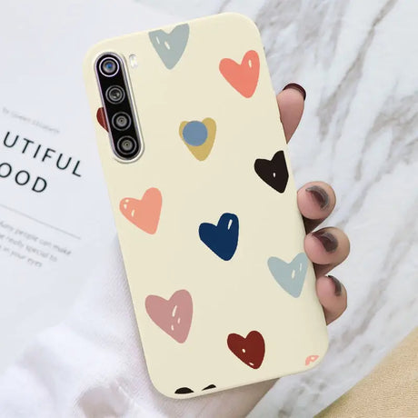 a woman holding a phone case with hearts on it