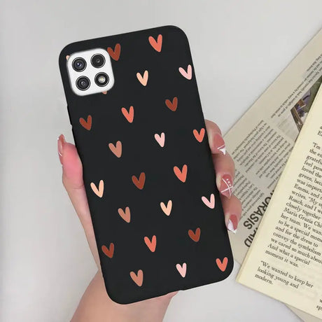 a woman holding a phone case with hearts on it