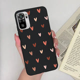 a woman holding a phone case with hearts on it