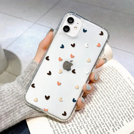 a woman holding a phone case with hearts on it