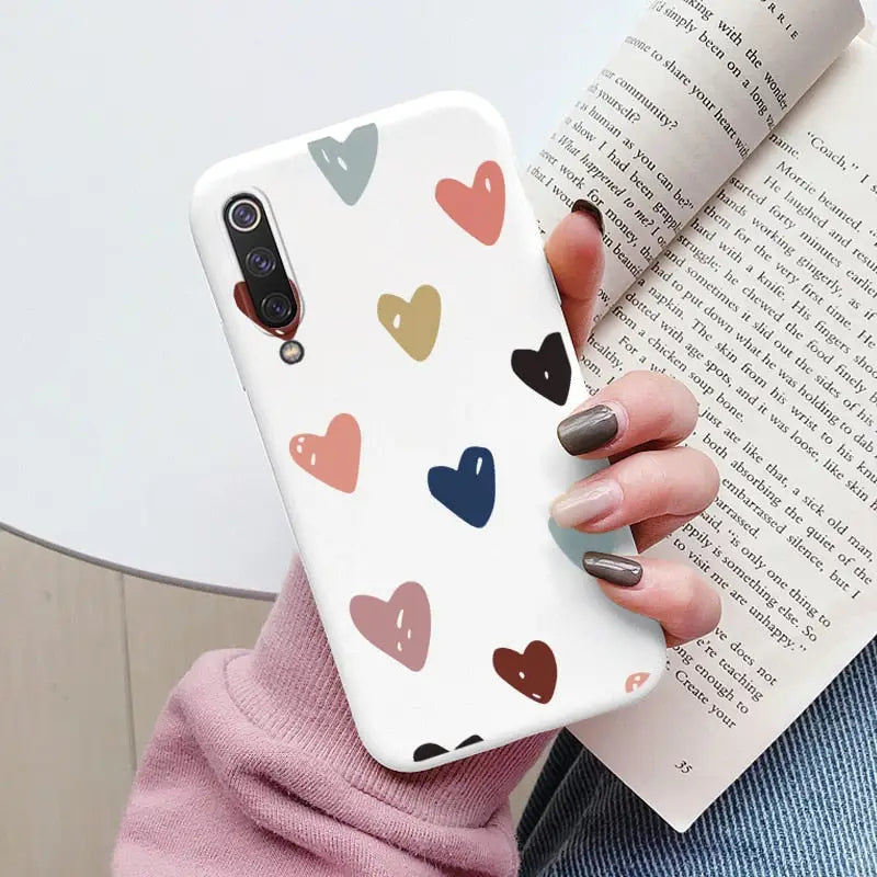 a woman holding a book and holding a phone case