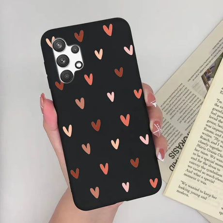 a woman holding a phone case with hearts on it