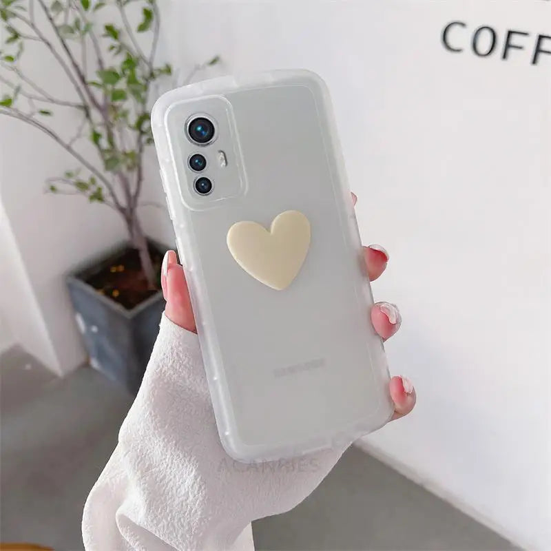 a woman holding a white phone case with a heart on it