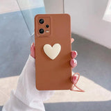 a woman holding a brown phone case with a heart on it