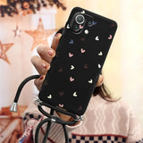 a woman holding a phone case with hearts on it