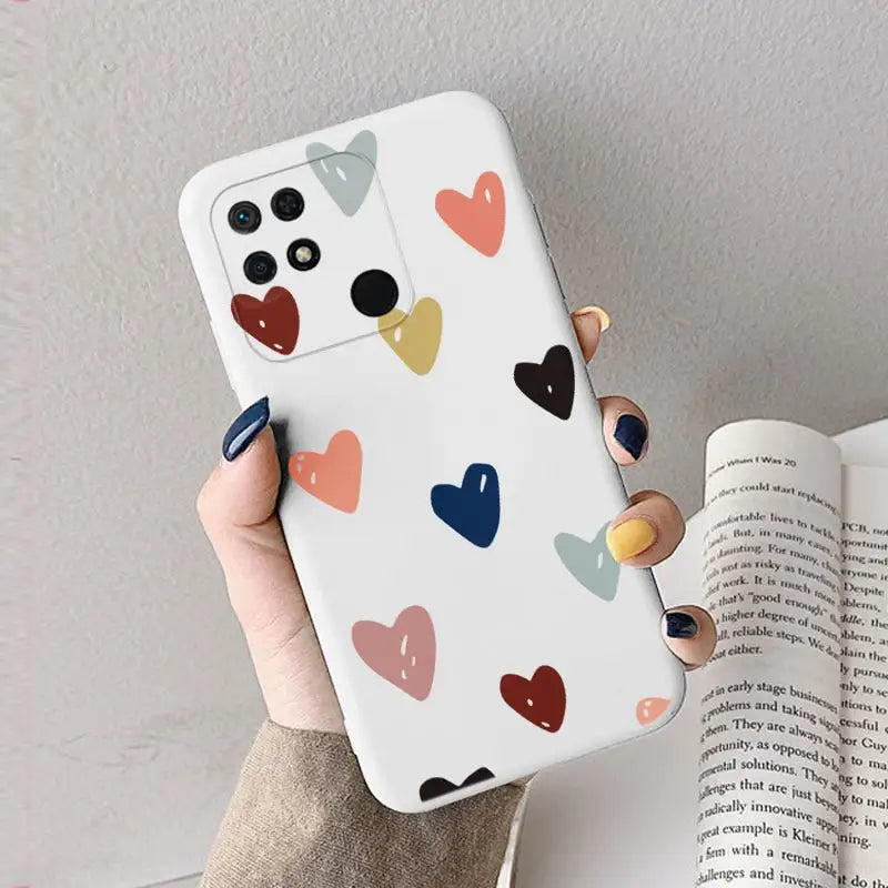 a woman holding a phone case with hearts on it