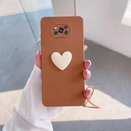 a woman holding a brown phone case with a heart on it