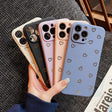 a woman holding three iphone cases with hearts on them