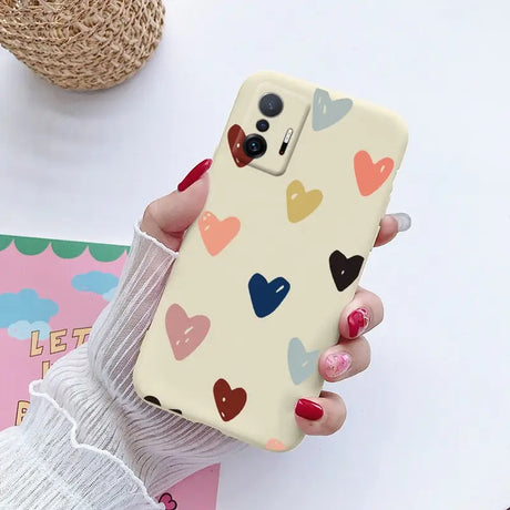 a woman holding a phone case with hearts on it