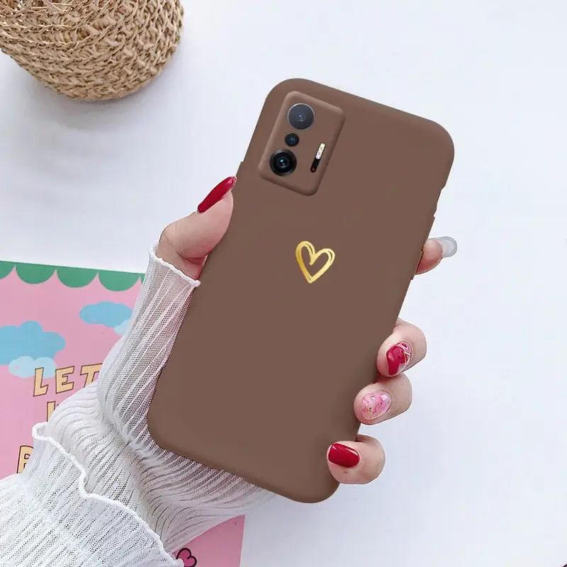 a woman holding a phone case with a heart on it