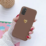 a woman holding a brown phone case with a heart on it