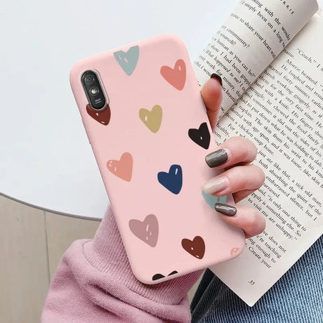 a woman holding a book and holding a phone case