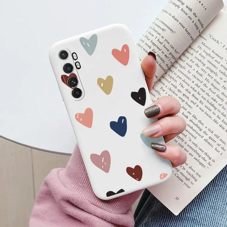 a woman holding a book and holding a phone case