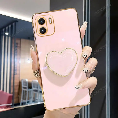 a woman holding a pink phone case with a heart