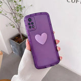 a woman holding a purple phone case with a heart on it