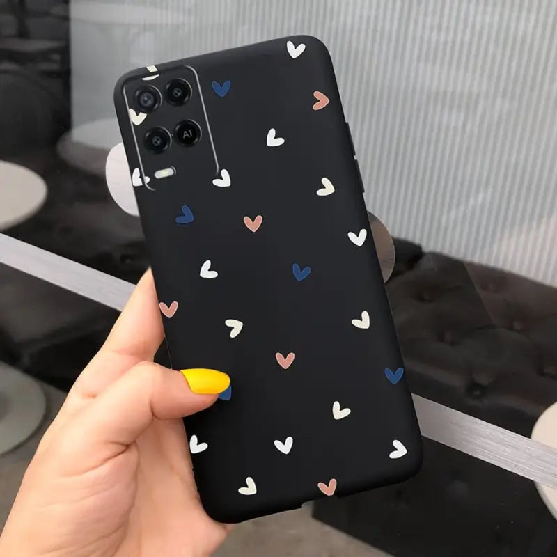 a hand holding a phone case with hearts on it