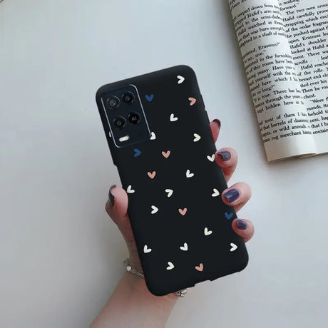 a woman holding a phone case with hearts on it