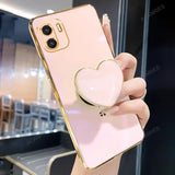 a woman holding a pink heart shaped phone case