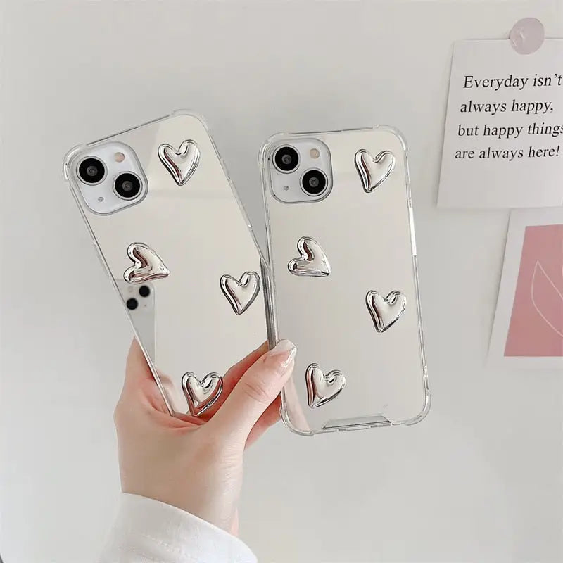 a woman holding a phone case with heart shaped design