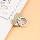 a gold heart shaped ring on a white book