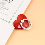 a red heart shaped ring on top of a magazine