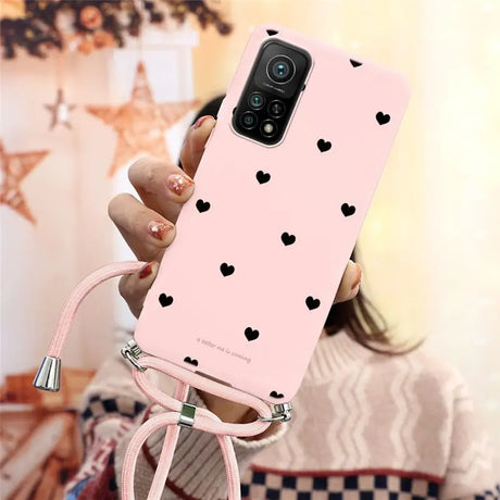 a woman holding a pink phone case with hearts on it