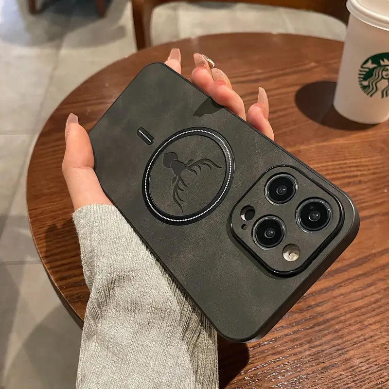 a hand holding a black case with a starbucks cup in the background