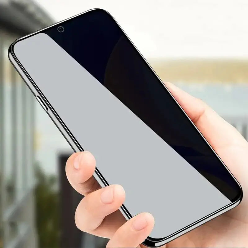 a hand holding a black iphone with a white screen