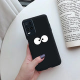 a hand holding a black phone case with a cartoon face on it