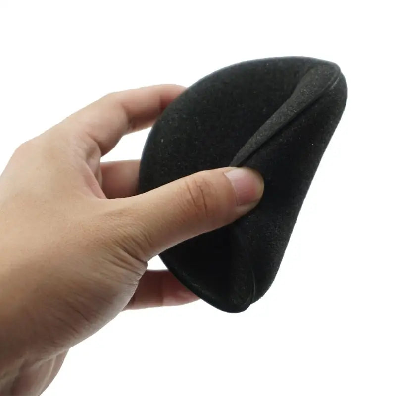 a hand holding a black sponge