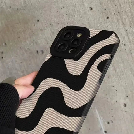 a hand holding a black and white case