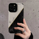 someone holding a phone up to take a picture of a black and white marble case