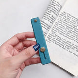 a hand holding a bookmark with a bookmark in the background