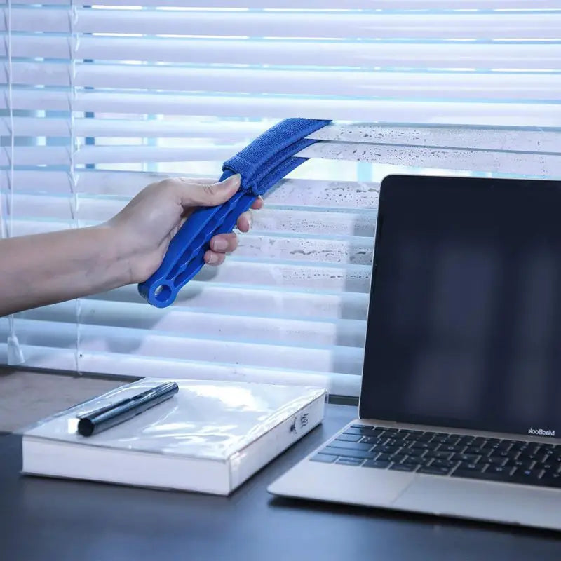 a person is using a laptop to clean the screen