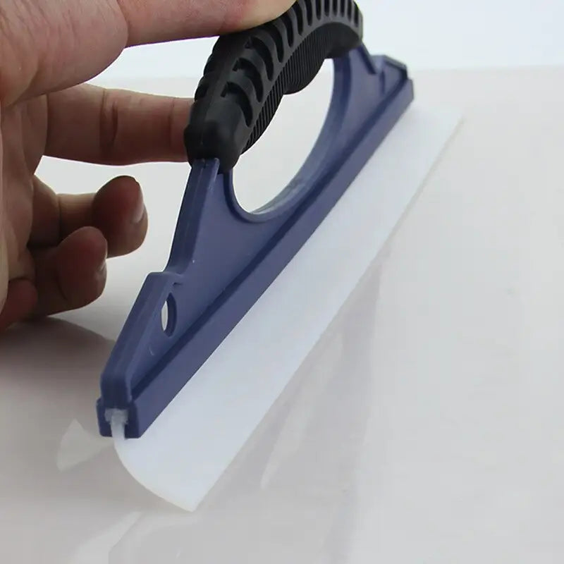 someone is using a plastic scrape to clean a white surface