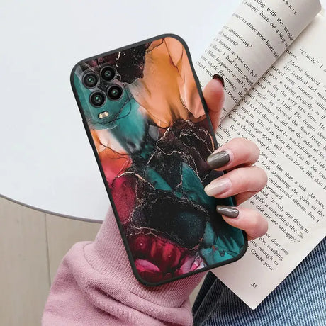 a woman holding a book and holding a phone case