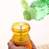 a hand holding a bottle with a green liquid