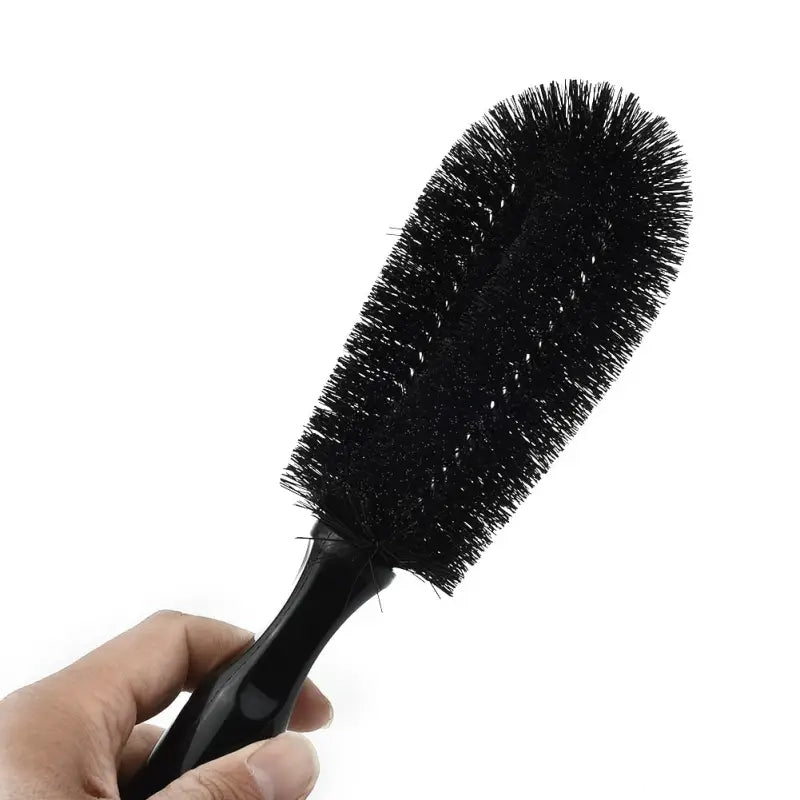 a hand holding a brush with a black handle