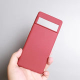 a hand holding a red card case