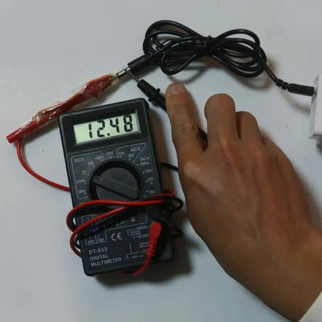 someone is holding a multimeter and a digital voltmor