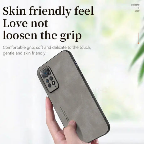 the back of a woman’s hand holding a gray iphone case